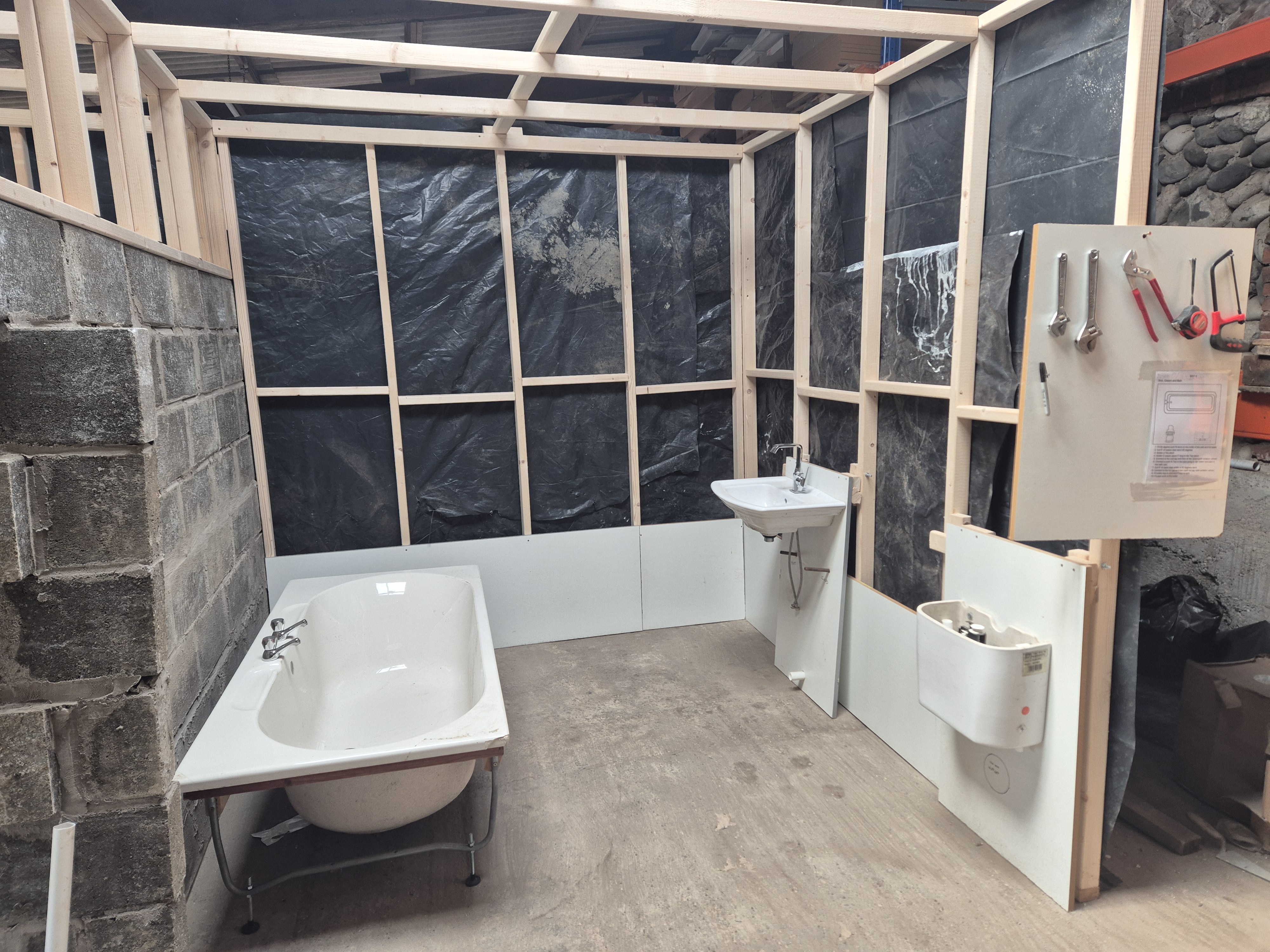 Plumbing training workshop mock room under construction for hands-on bathroom fitting practice